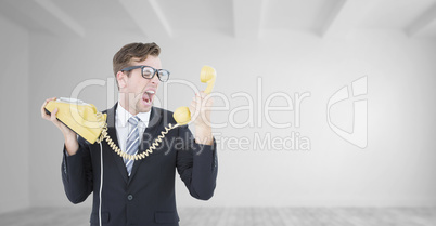 Composite image of geeky businessman shouting at telephone