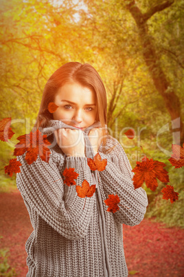 Composite image of pretty girl in winter jumper looking at camer