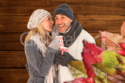 Composite image of happy couple gossiping while drinking hot tea