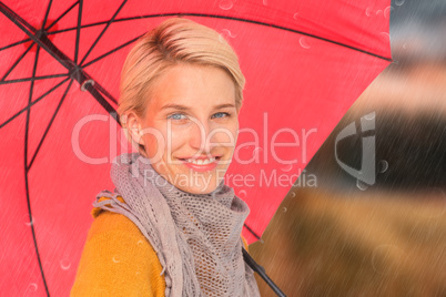 Composite image of smiling woman holding an umbrella