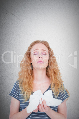 Composite image of sick blonde woman holding paper tissue