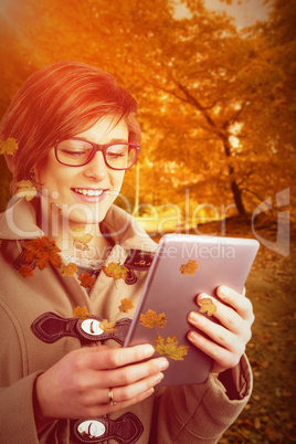 Composite image of smiling woman in glasses using digital tablet
