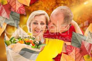 Composite image of mature man kissing his partner holding flower
