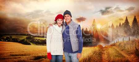 Composite image of happy couple in warm clothing