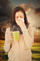 Composite image of sick woman blowing her nose while holding a g