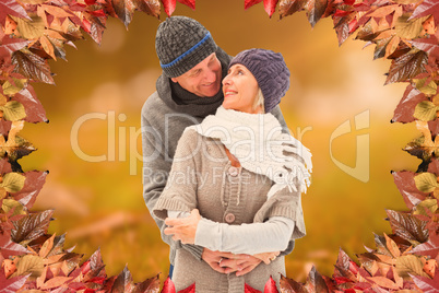 Composite image of happy mature couple in winter clothes embraci