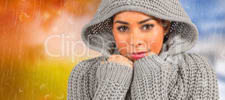 Composite image of pretty girl in winter jumper looking at camer