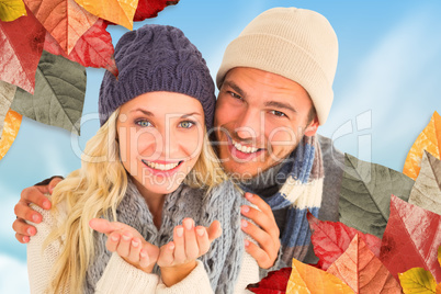 Composite image of attractive couple in winter fashion smiling a