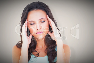 Composite image of pretty brunette with a headache
