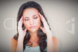 Composite image of pretty brunette with a headache