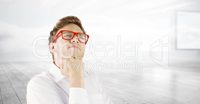 Composite image of young geeky businessman with hand on chin