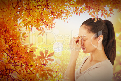 Composite image of brunette suffering from migraine