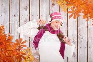 Composite image of winter brunette listening to music