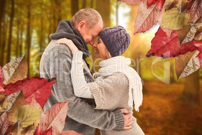 Composite image of happy mature couple in winter clothes embraci Composite image of happy mature couple in winter clothes embraci
