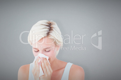 Composite image of sick woman blowing her nose