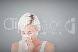 Composite image of sick woman blowing her nose