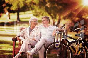 Composite image of elderly couple with their bikes