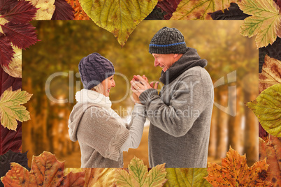 Composite image of happy mature couple in winter clothes embraci