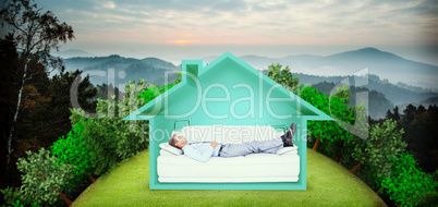 Composite image of businessman lying on sofa