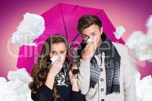 Composite image of couple blowing nose while holding umbrella