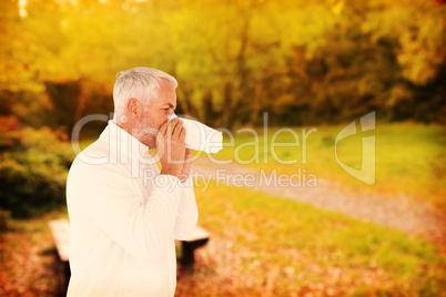 Composite image of sick man in winter fashion sneezing