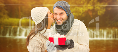 Composite image of winter couple holding gift