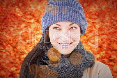 Composite image of attractive brunette looking up wearing warm c