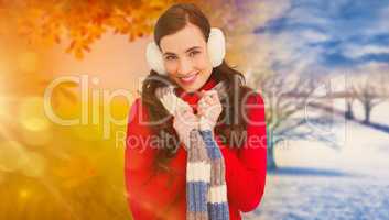 Composite image of happy brunette in winter clothes smiling at c