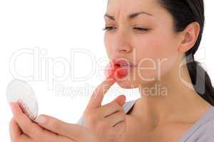Composite image of worried woman looking at her lips