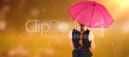 Composite image of pretty redhead businesswoman holding umbrella