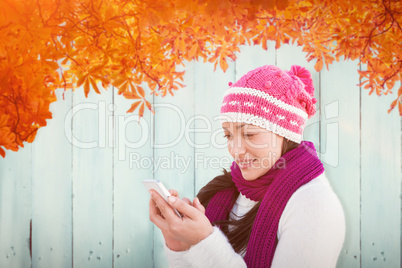 Composite image of attractive woman using her smartphone