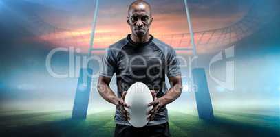 Composite image of portrait of serious athlete holding rugby ball