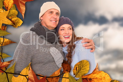 Composite image of couple in warm clothing embracing