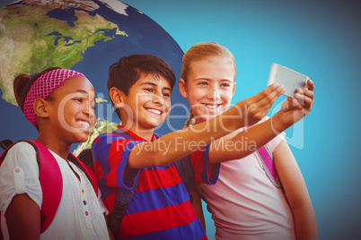 Composite image of happy kids taking selfie in school corridor