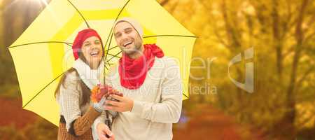 Composite image of autumn couple holding umbrella