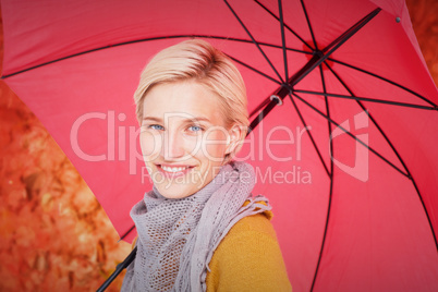 Composite image of smiling woman holding an umbrella