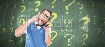 Composite image of geeky hipster talking on a retro cellphone