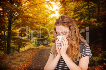 Composite image of sick blonde woman blowing her nose