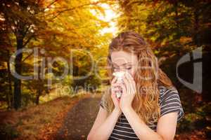 Composite image of sick blonde woman blowing her nose