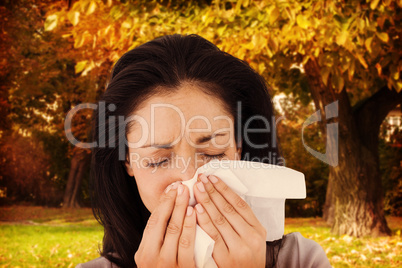 Composite image of sick brunette blowing her nose