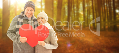 Composite image of happy mature couple in winter clothes holding