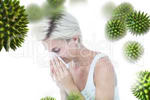Composite image of sick woman blowing her nose