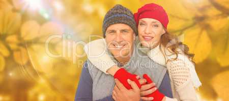 Composite image of happy couple in warm clothing