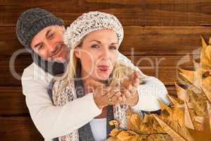 Composite image of husband hugging wife from behind as she blows