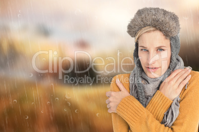 Composite image of woman in winter clothes shivering over white