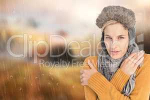 Composite image of woman in winter clothes shivering over white