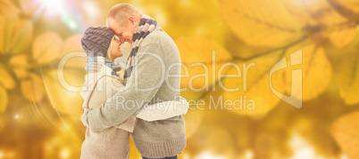 Composite image of happy mature couple in winter clothes hugging