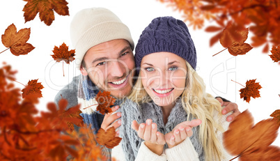 Composite image of attractive couple in winter fashion smiling a