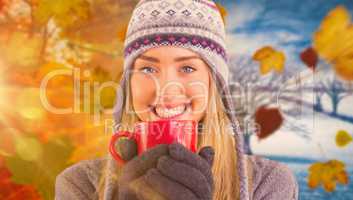 Composite image of happy blonde in winter clothes holding mug