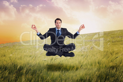 Composite image of calm businessman sitting in lotus pose